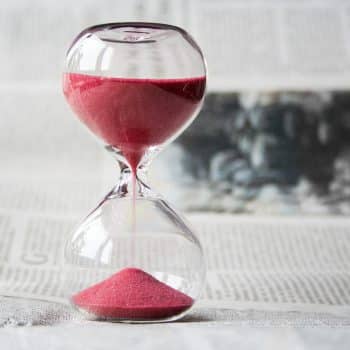 Hourglass with red sand falling from the top.