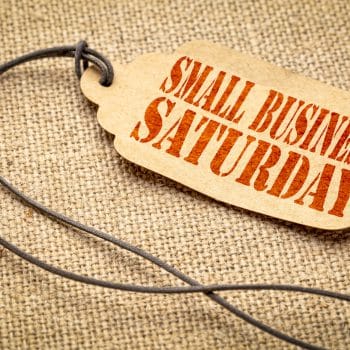 Small Business Saturday sign - a paper price tag with a twine iagainst burlap canvas