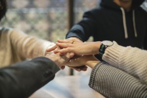 Five different hands placed on top of each other