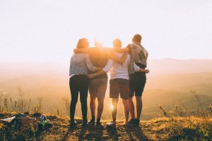 four adult friends looking into the sunset