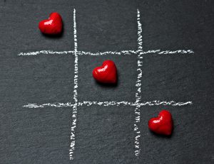 Three hearts in a row in tic tac toe setting. Polyamory