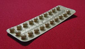 little round white birth control pills in package.