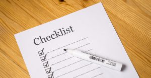 white paper that says checklist with boxes down a line with checkmarks in them. 