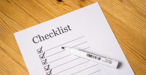 white paper that says checklist with boxes down a line with checkmarks in them.