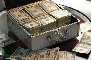 metal suitcase opened with stacks of hundred dollar bills rubber banned together.