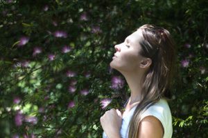 Person meditating near a tree with flowers