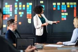 adults brainstorming with post-its on a board