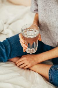 glass of water held in a lap