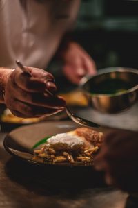 Bluured vision of man spreading sauce on a dish.