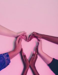Multiple different hands forming the shape of a heart.