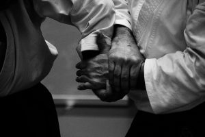 A set of hands grabbing another set in a self defense manner.