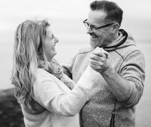 An older caucasian woman and older caucasian man holding hands dancing. Senior dancing.