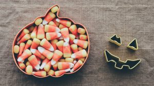 Candy corn in a pumpkin shaped plate.