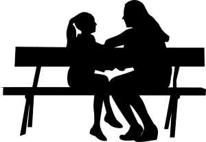 Silhouette of a woman and young girl on a bench facing each other.