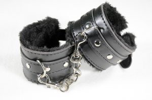 black leather handcuffs with black fur inside.