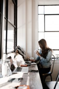 brunette freelancer with coffee mug at computer