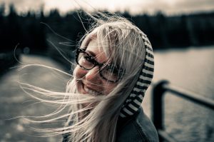 Young caucasian woman with blonde hair , and glasses ooking back smiling