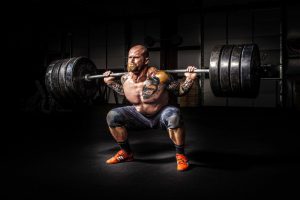 man squatting heavy weight and straining for men's health