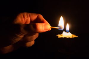 person lighting a candle they made