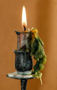 candle burning with wax falling down the sides