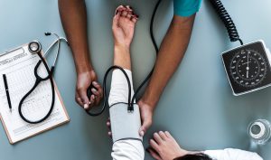 doctor doing blood pressure for men's health