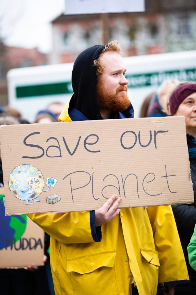 save our planet sign held by an activist