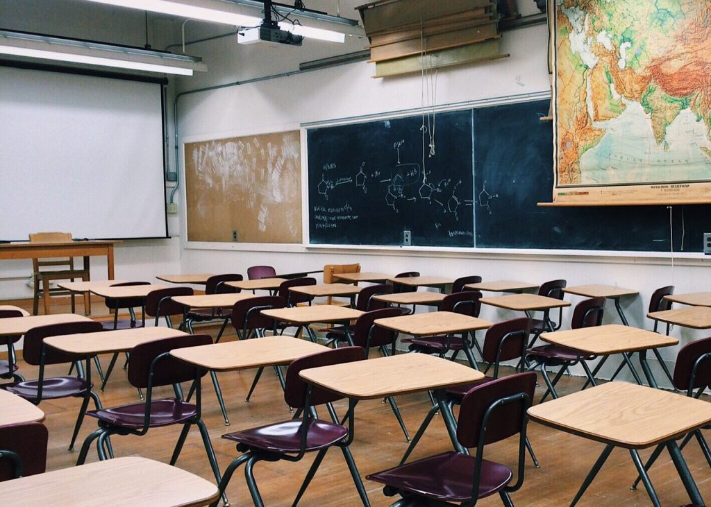Empty classroom with desks and chalkboards.