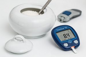 Diabetes machine, a bowl of sugar, and testing machine. 