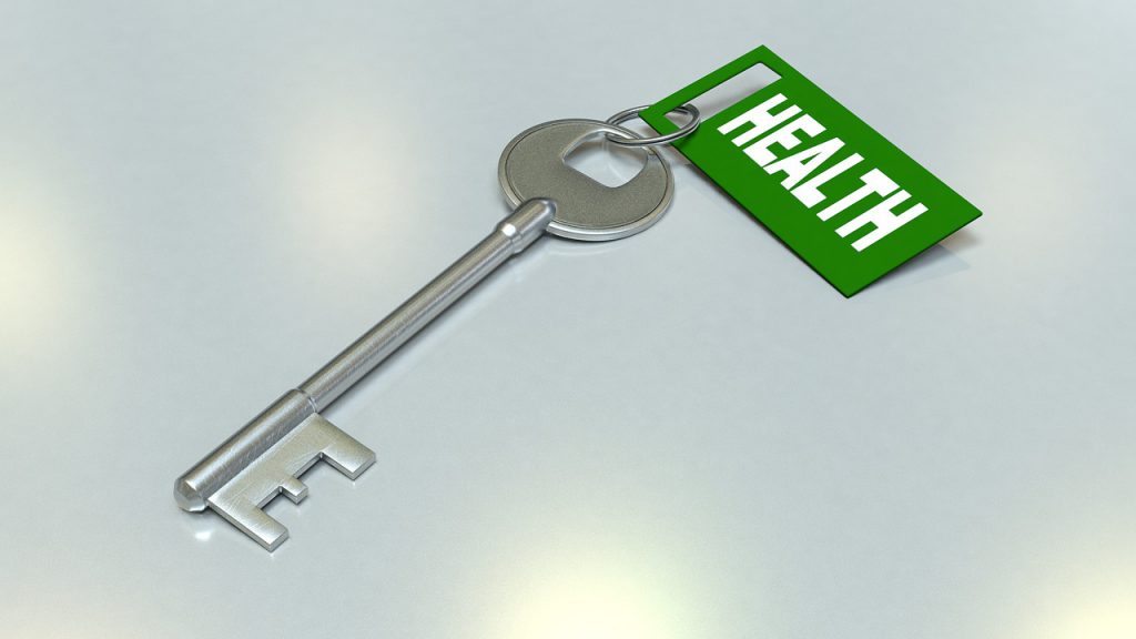 A slver key with a green tag on it that says "health"