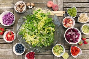 Large bowl in the middle filled with lettuce, with little bowls surrounding it filled with fuits and vegetables.