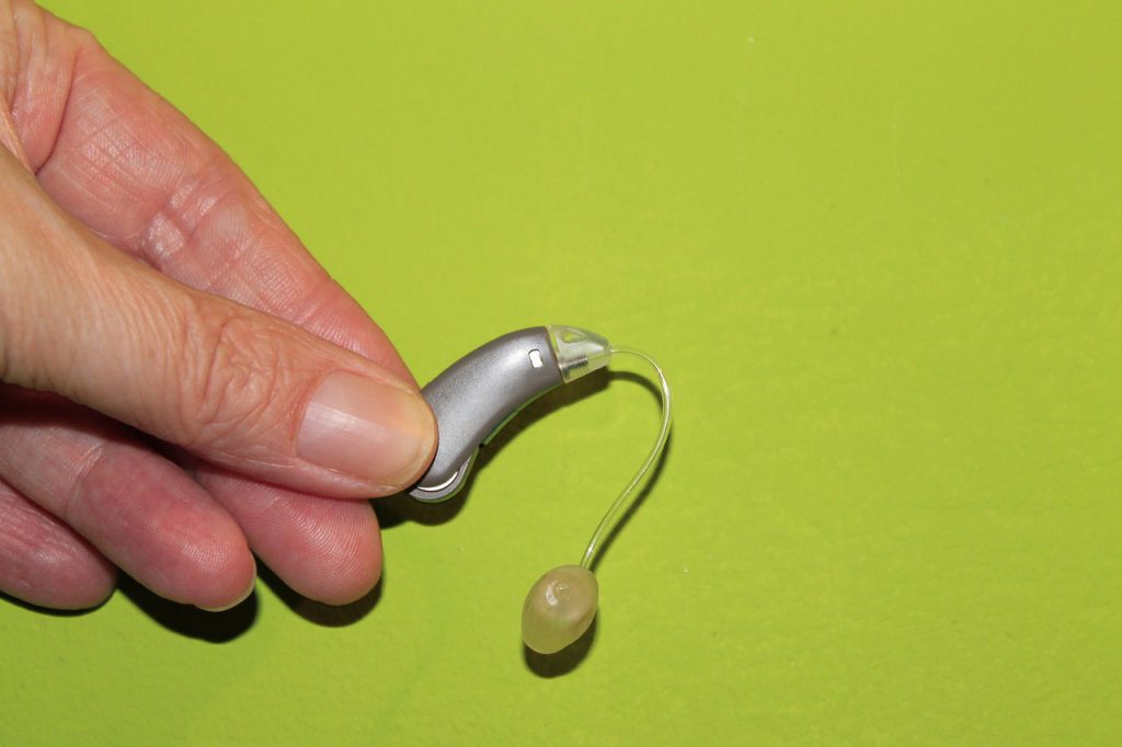 Hand holding a hearing aid.
