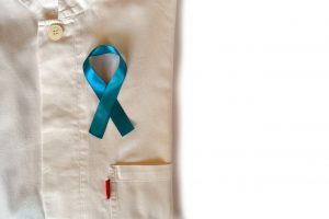 Blue ribbon placed on top of a folded white collared shirt for prostate cancer