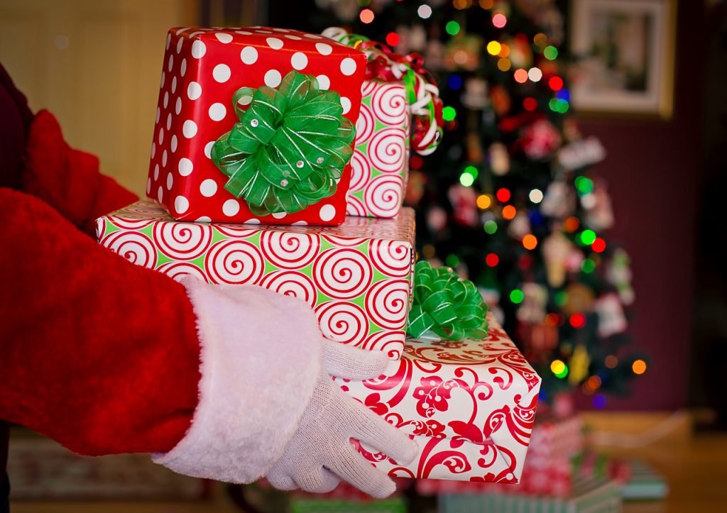 Santa hands holding wrapped gifts