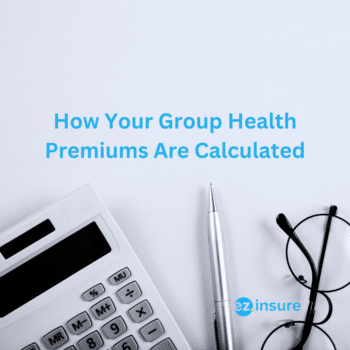 How Your Group Health Premiums Are Calculated text overlaying image of a ben and calculator on a white table