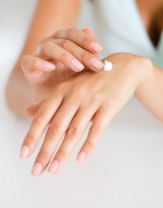 person applying lotion to their hand to help with loose skin