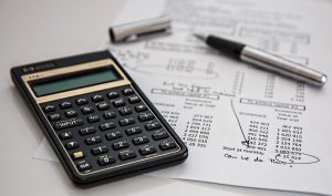 calculator, pen, and chart for an HSA or FSA