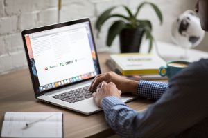 computer desk with person emailing to keep information safe