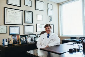 doctor sitting behind desk to discuss the best health insurance plan