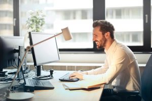 man sending a follow-up email at his desk 