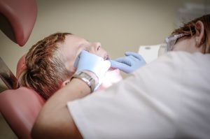dentist performing oral surgery on patient for dental care