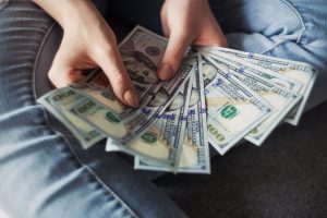person holding a bunch of money that EZ.insure helped them get