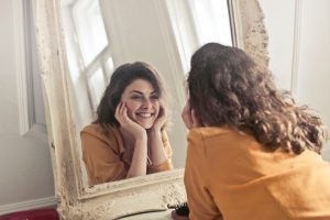 woman using a mirror for optimism