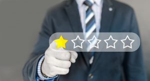 a man with a suit and tie with his finger choosing a one star review.
