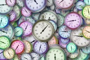 different colored clocks of all sizes layered on top of each other