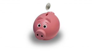 pink piggy bank with a coin being thrown in