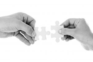 2 hands with a puzzle piece in each