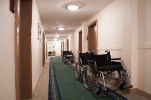 a hallway with wheelchairs lined up behind one another