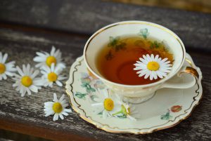 tea cup with tea in it and a daisy