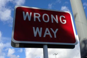 red sign with the words "wrong way" on it
