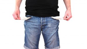 Man wit black shirt on and jeans, holding out empty jean pockets on both sides.